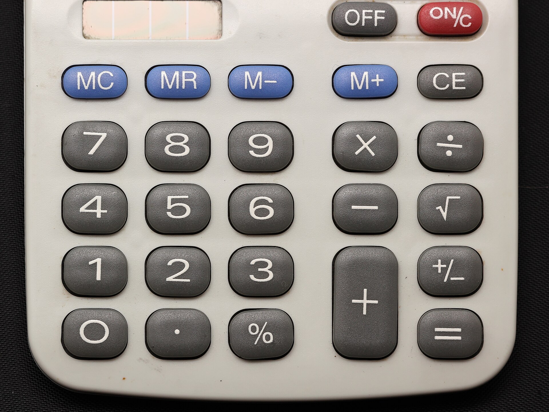 Close-up of a grey calculator keypad with number and memory keys